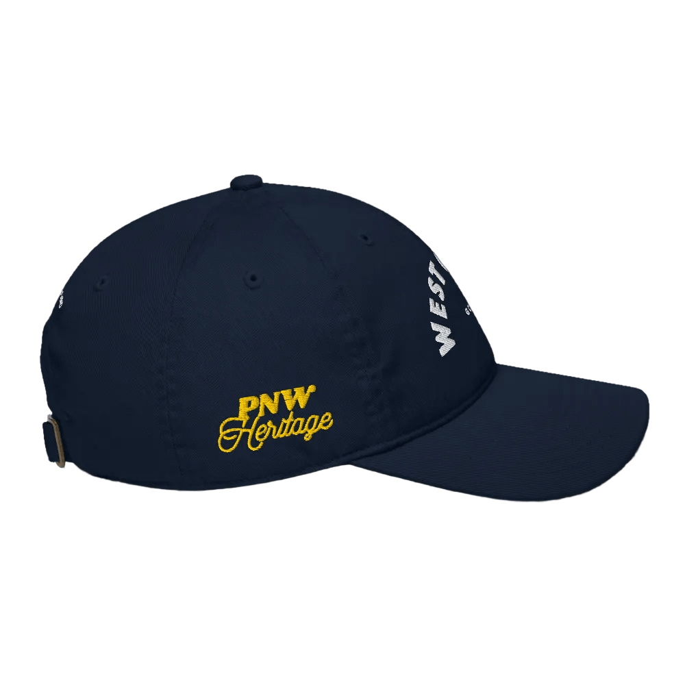 Navy blue cap with &#39;PNW Heritage&#39; in yellow and &#39;WEST&#39; in white on a black background