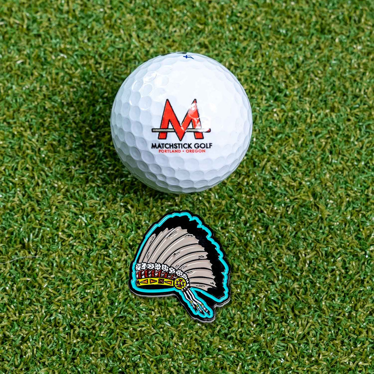 native american indian headdress golf ball marker on grass with ball