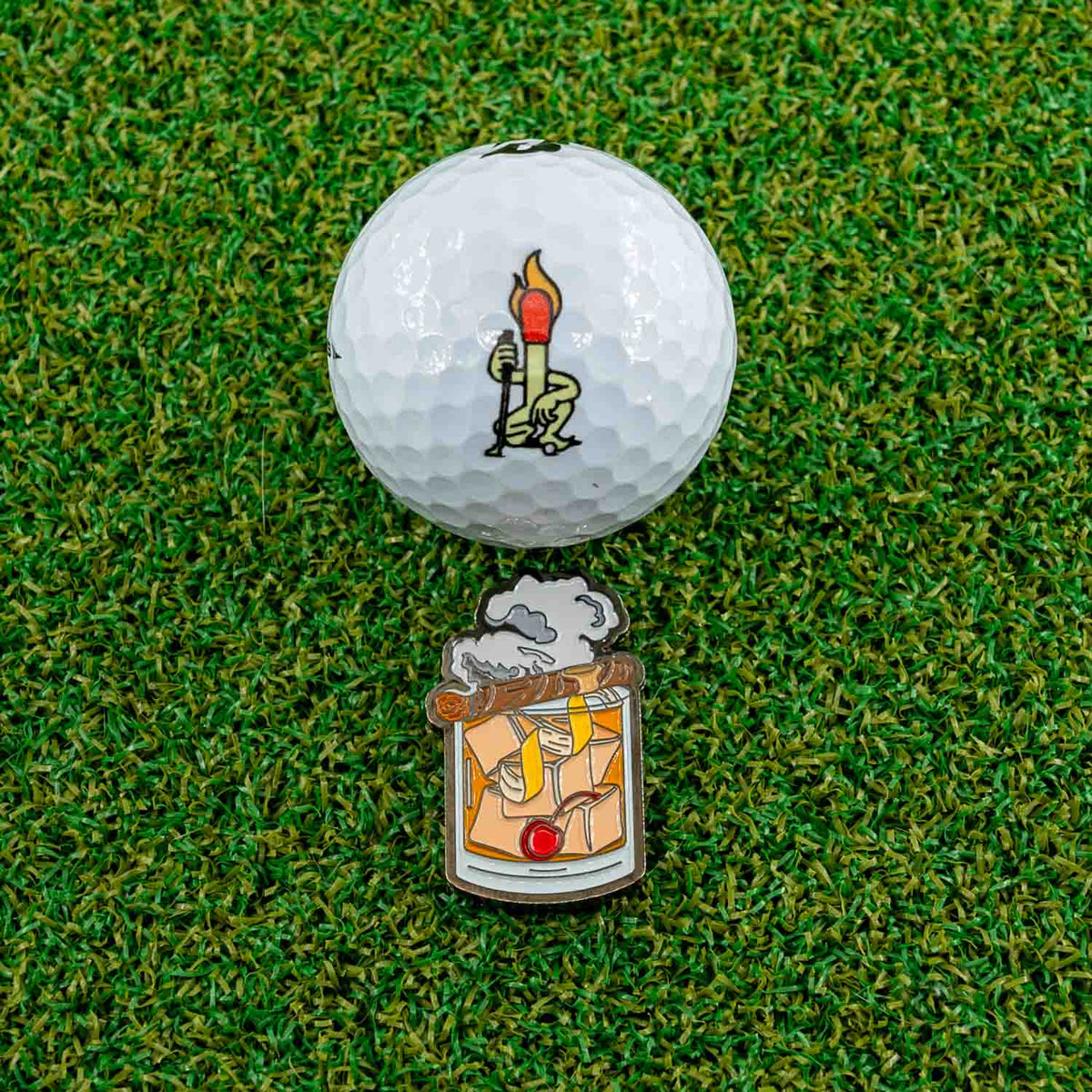 old fashioned with cigar golf ball marker grass golf ball