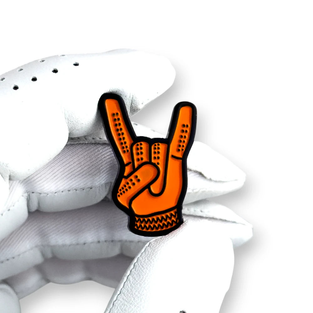 orange devil horns golf ball marker held in white golf glove