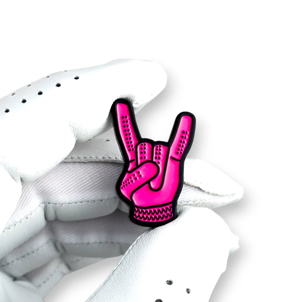 pink devil horns golf ball marker held in white golf glove