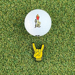 yellow devil horns golf ball marker grass and golf ball