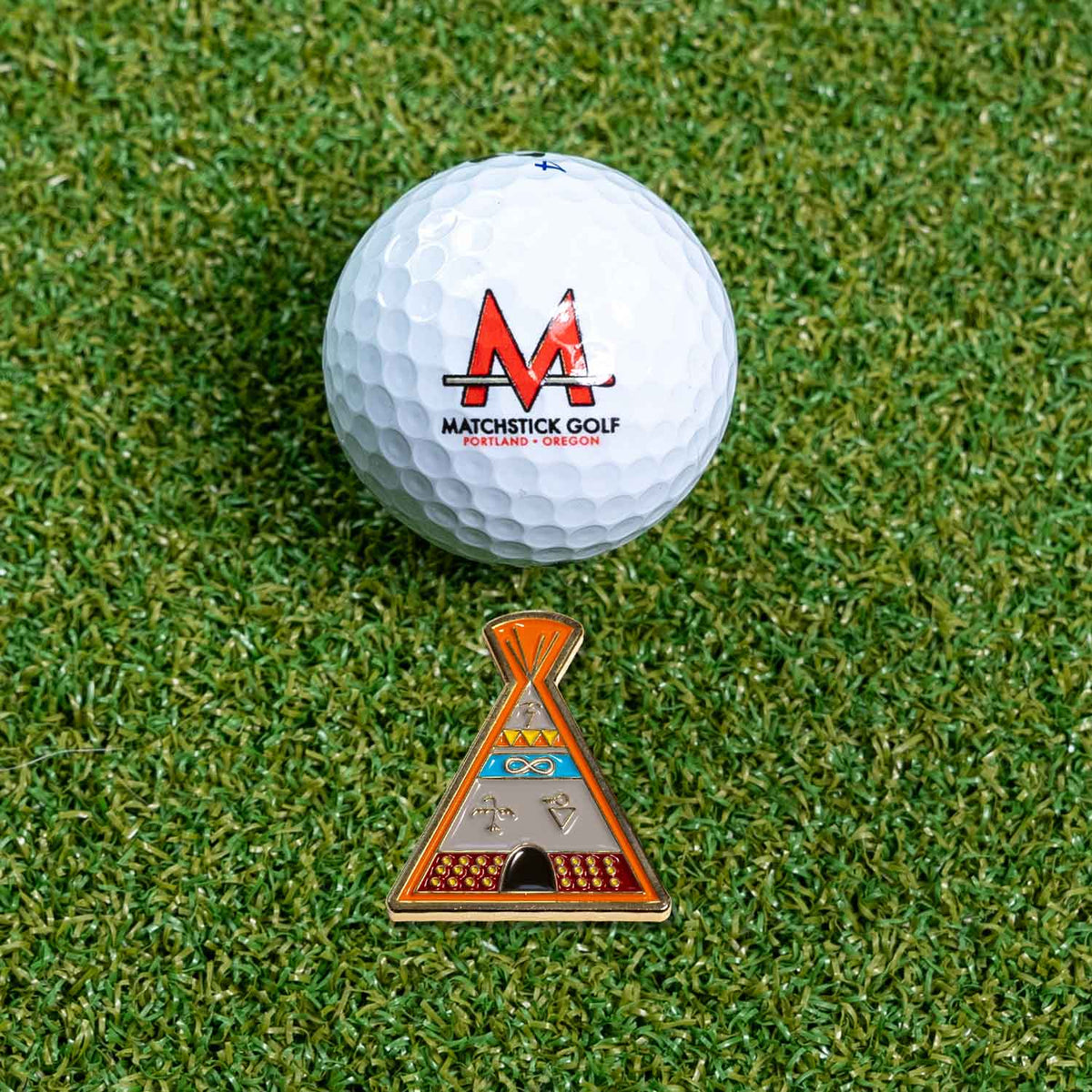 native american indian tipi golf ball marker on grass with ball
