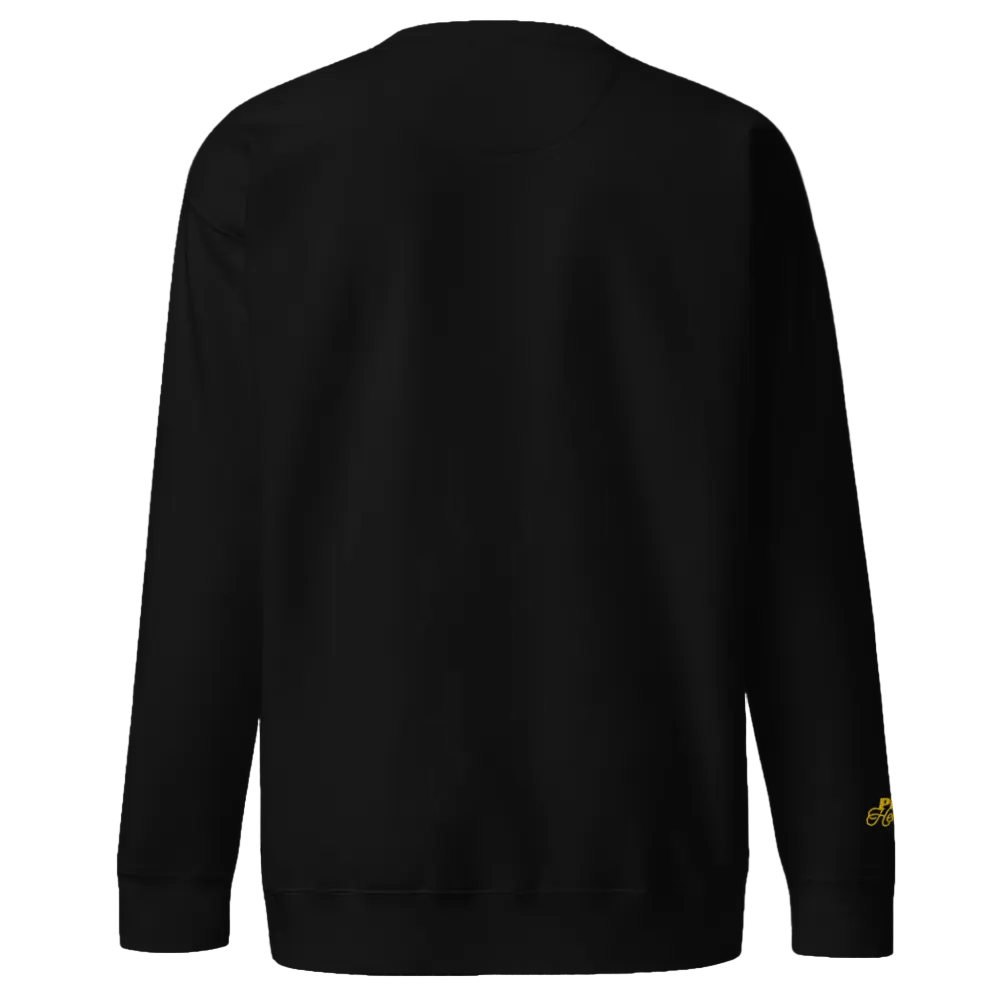 Black sweatshirt with a small yellow logo on the sleeve against a black background