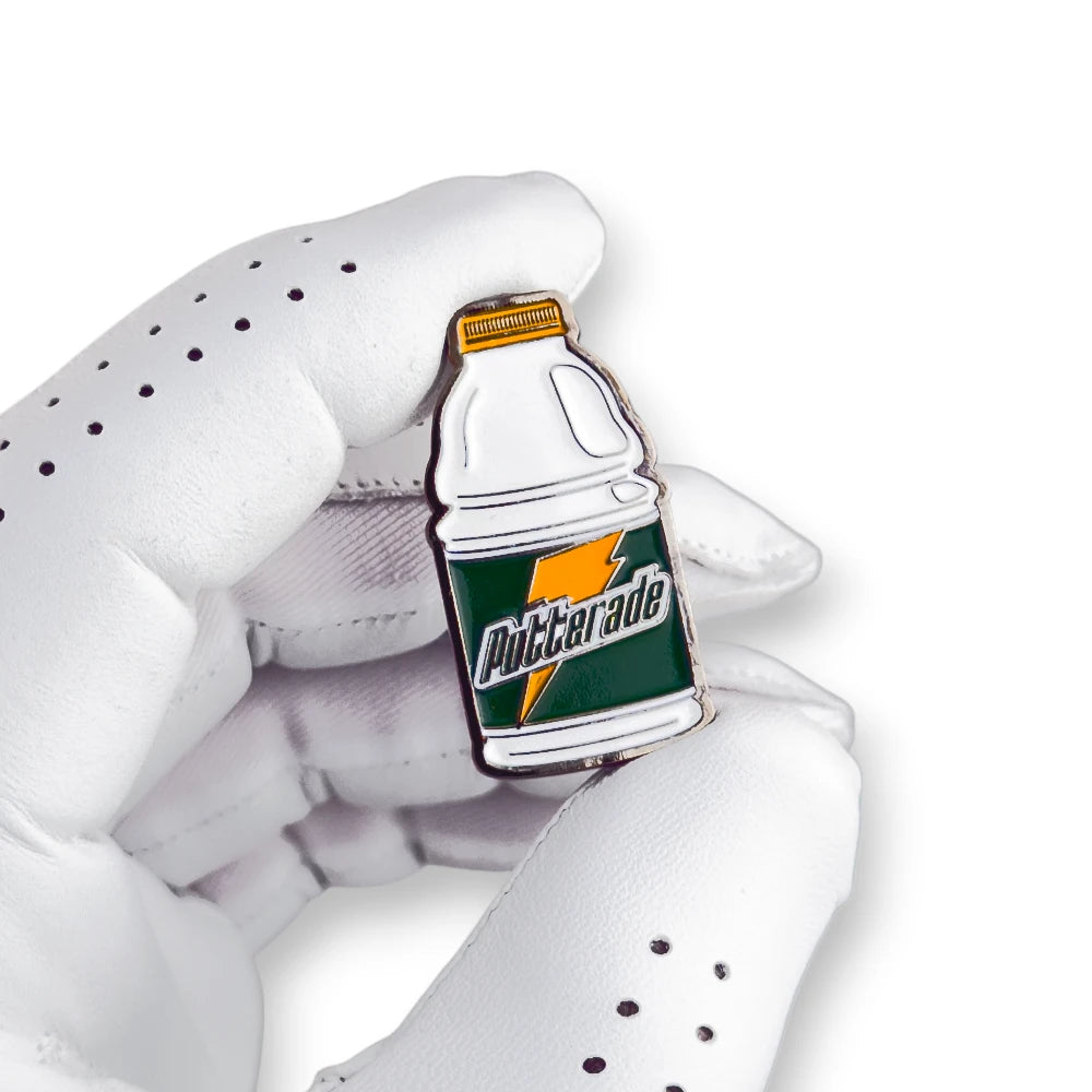 white gatorade putterade golf ball marker enamel held in golf glove hand
