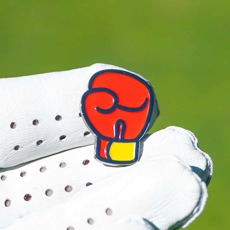boxing glove golf ball marker in fingertips of golf glove