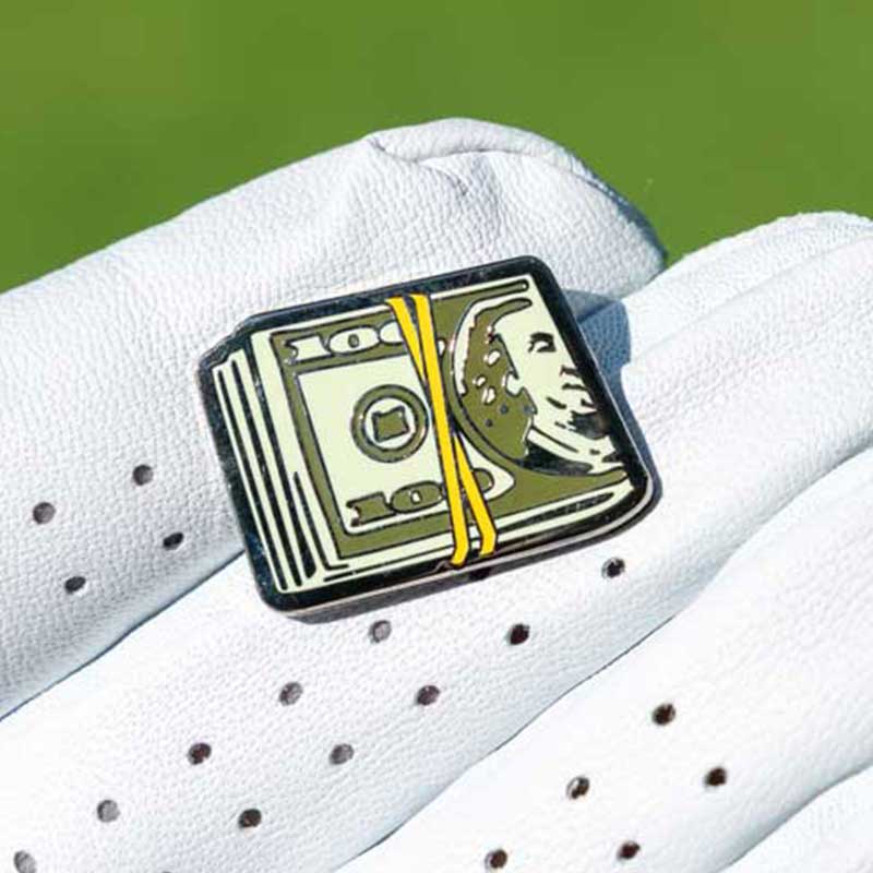 cash golf ball marker held in palm of golf glove