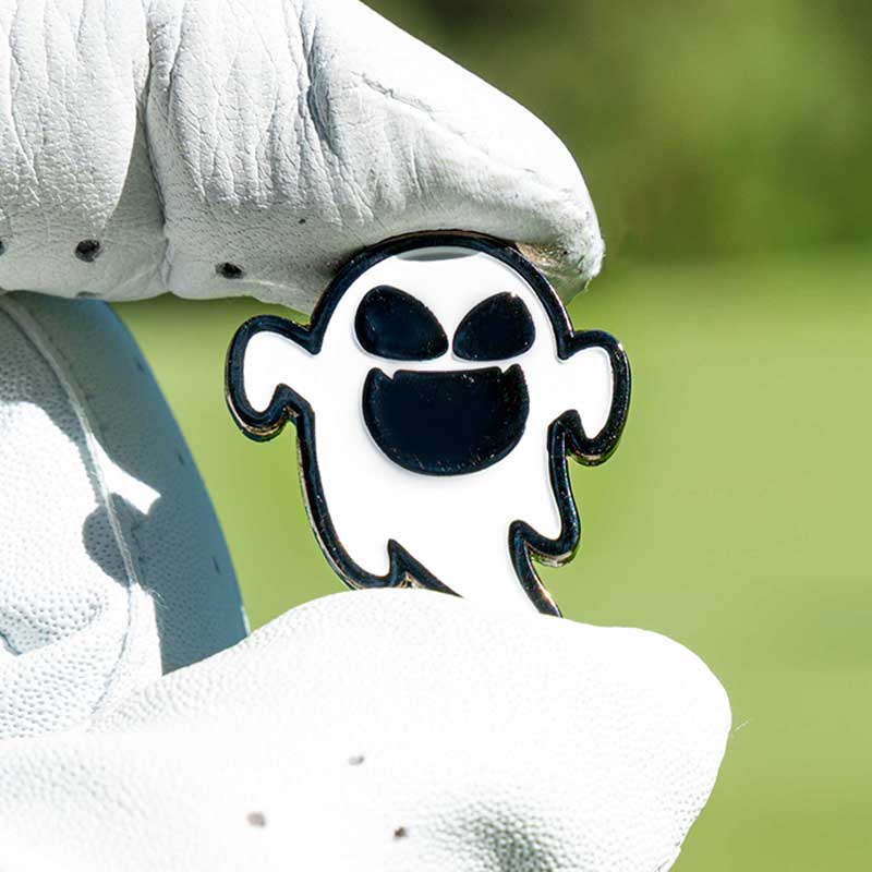 halloween ghost golf ball marker held in glove