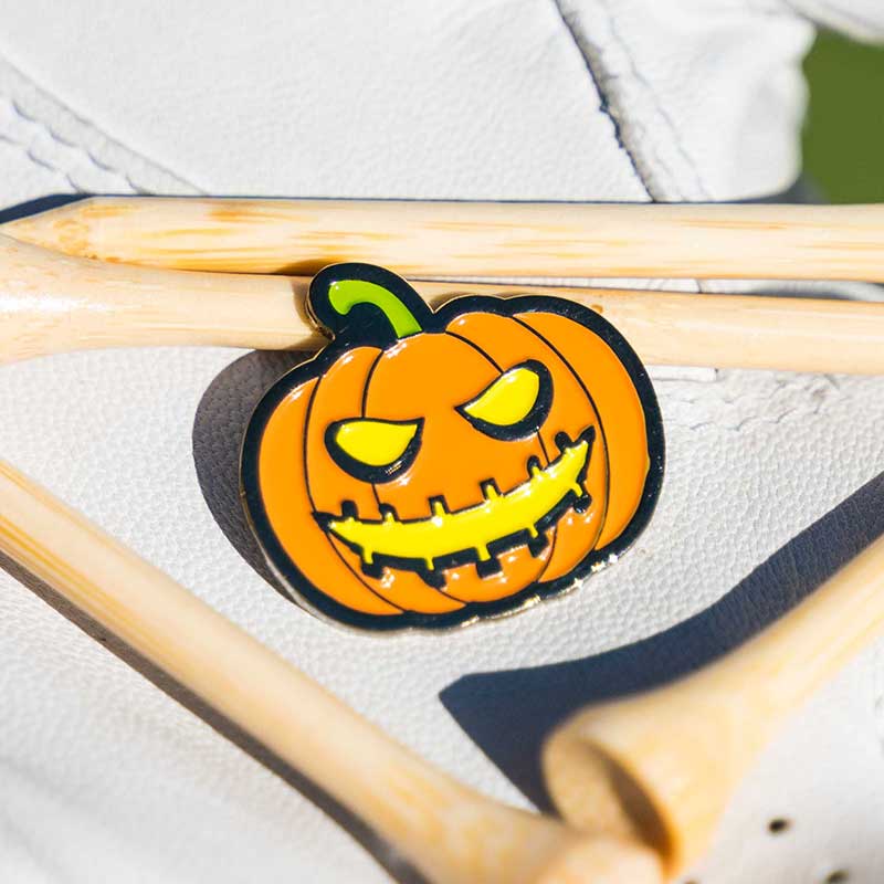 halloween jack-o-lantern golf ball marker with golf tees in glove