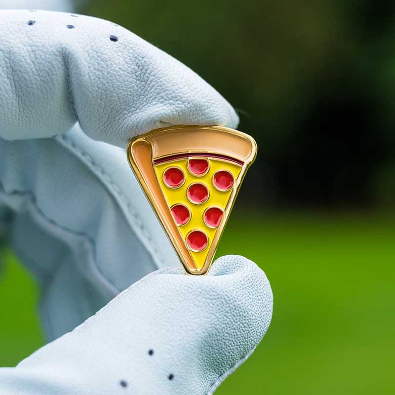 pepperoni pizza golf ball marker held in golf glove fingers
