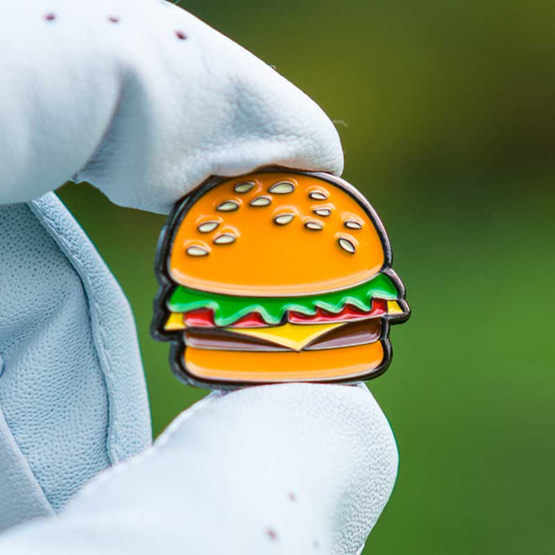 royale cheeseburger golf ball marker textured magnetic held in gloved fingers